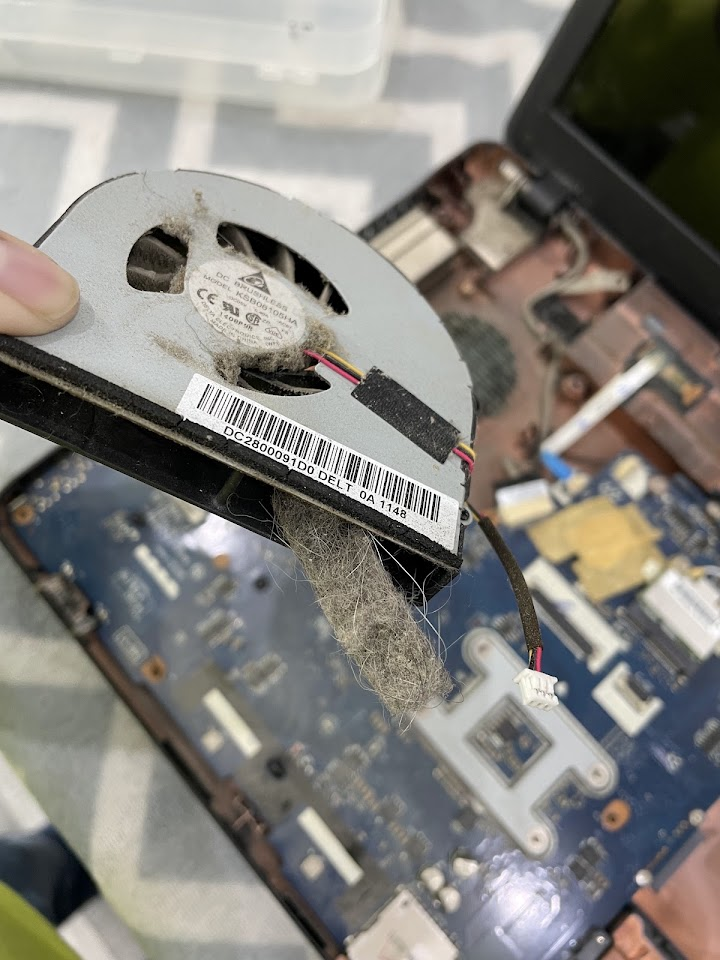 A clogged laptop cooling fan being cleaned during servicing at the PMM Solutions Morden workshop, typical of Ewell's overheating home machines